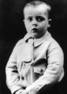 A young boy in a coat and hat.